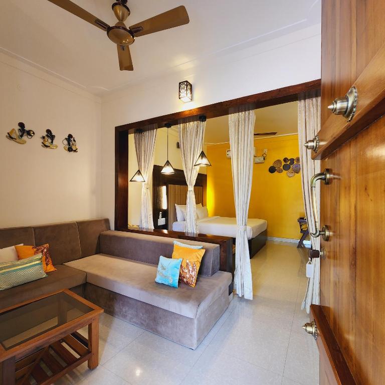 a living room with a couch and a bed at Riyavar Luxury Stay in Siddapur