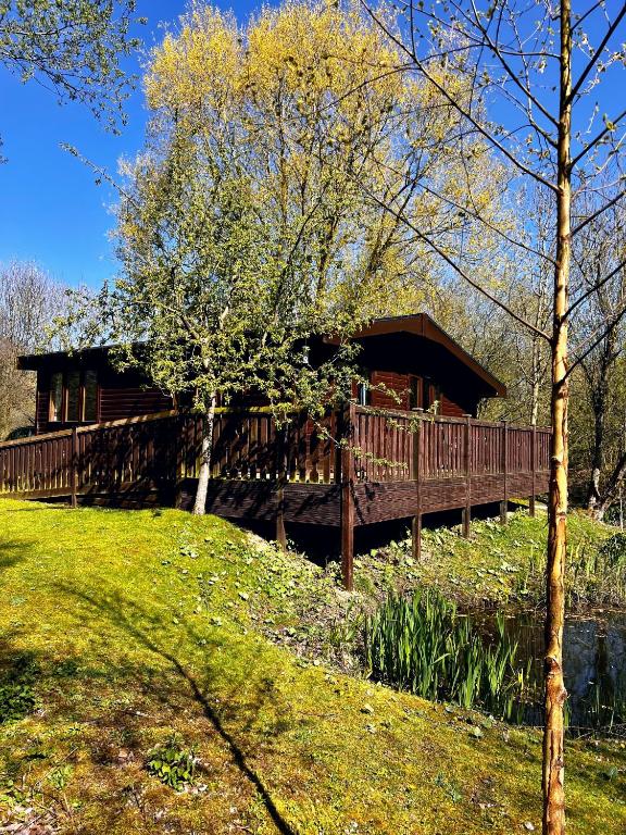 una casa de madera en un puente sobre un río en Secluded Rustic Cabin - A Digital Detox Paradise. en York