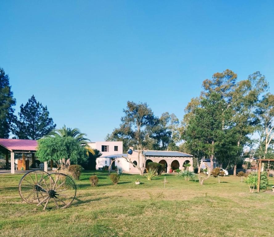塔夸倫博的住宿－Mahatma x habitación，一座花园,在一座建筑前有一台古老的拖拉机