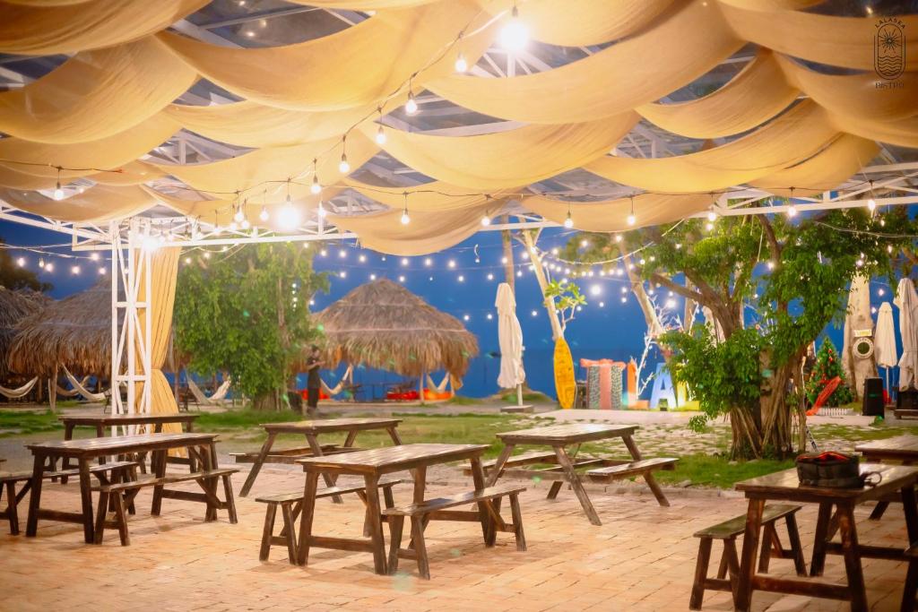 a group of picnic tables under a tent with lights at LALASEA BISTRO (Camping, Food & Drink) in Ha Tien