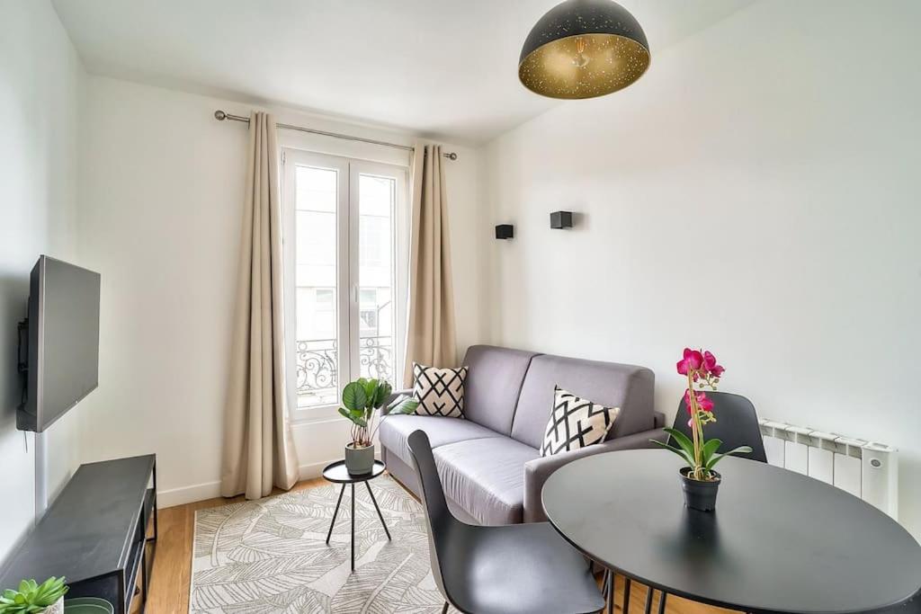 uma sala de estar com um sofá e uma mesa em Splendid apartment for 2 people em Aubervilliers