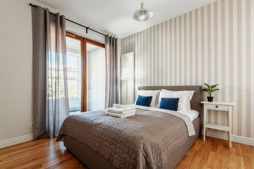 ein Schlafzimmer mit einem großen Bett mit blauen Kissen in der Unterkunft Apartament Premium Plac Litewski 7 in Lublin
