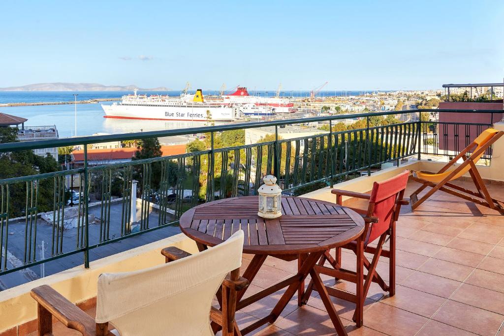 a balcony with a table and chairs and a boat at City Center Modern Penthouse in Heraklio Town