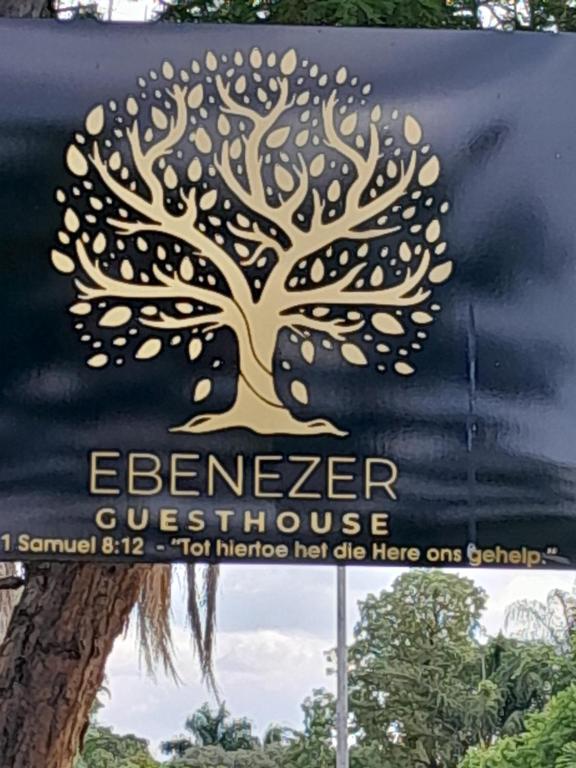 a sign with a tree on the side of a building at Ebenezer Self Catering in Groblersdal