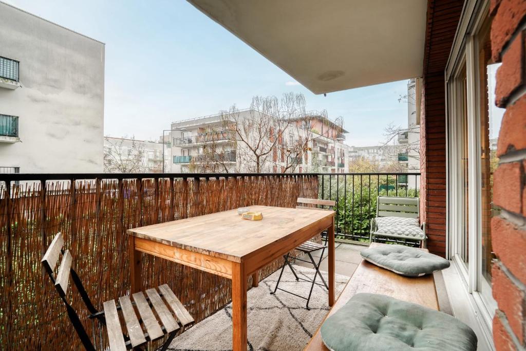 a patio with a wooden table and chairs on a balcony at Magnifique Appart Stade de France gare Terasse Paris 6 pers in Saint-Denis