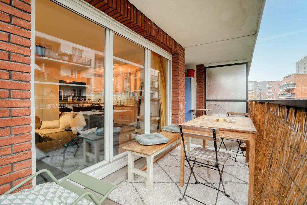 a patio with a table and chairs on a balcony at Magnifique Appart Stade de France gare Terasse Paris 6 pers in Saint-Denis