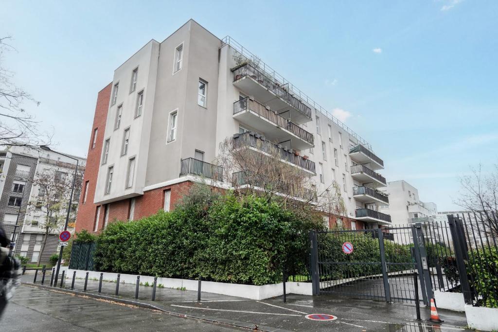 a tall apartment building on a city street at Magnifique Appart Stade de France gare Terasse Paris 6 pers in Saint-Denis