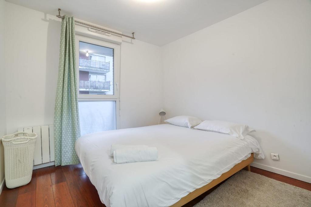 a white bed in a room with a window at Magnifique Appart Stade de France gare Terasse Paris 6 pers in Saint-Denis