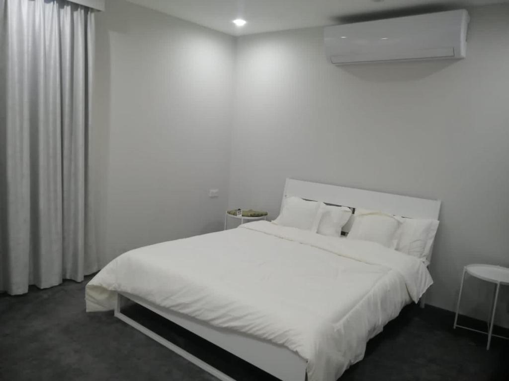 a white bedroom with a large bed with white sheets and pillows at مزرعة واستراحة المنامة 