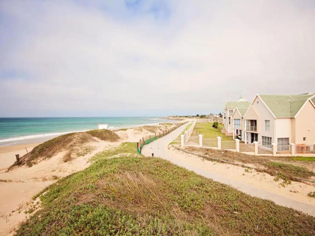 a house on the beach next to the ocean at Summerseas in Summerstrand