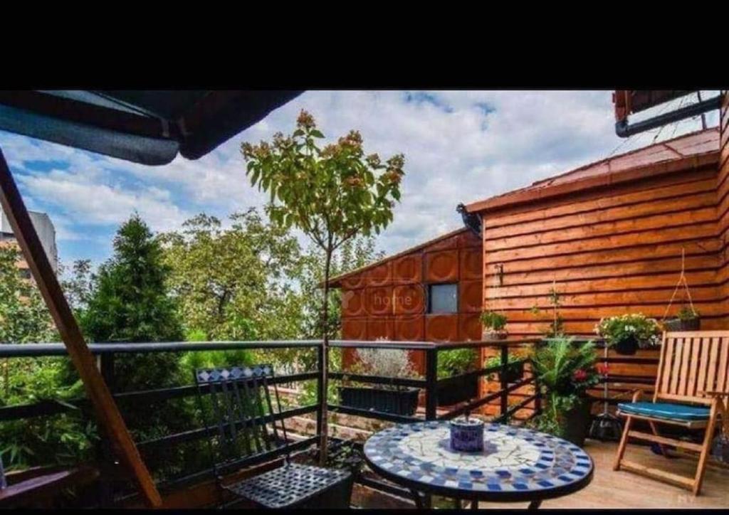 a balcony of a log cabin with a table at Vake View Villa in Tbilisi City