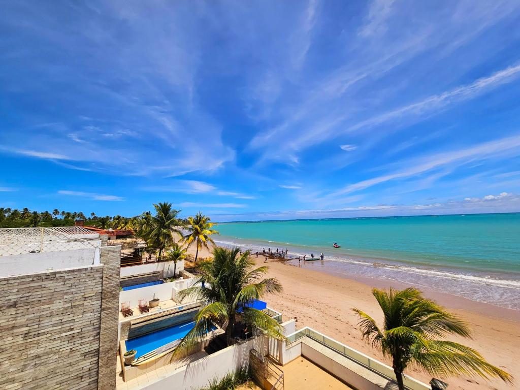 a view of a beach with palm trees and the ocean at Romantic Sea Villa w/AMAZING SEA VIEW - DIRECTLY ON THE BEACH! in Maceió