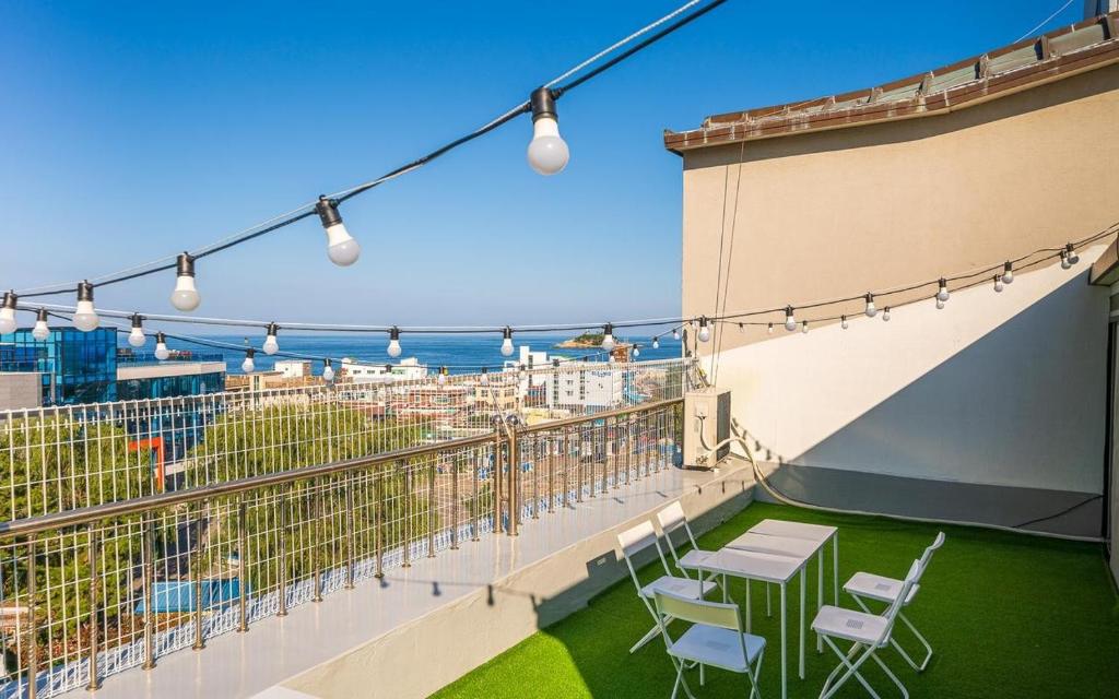 a balcony with a table and chairs and the ocean at Sokcho Time Hotel in Sokcho