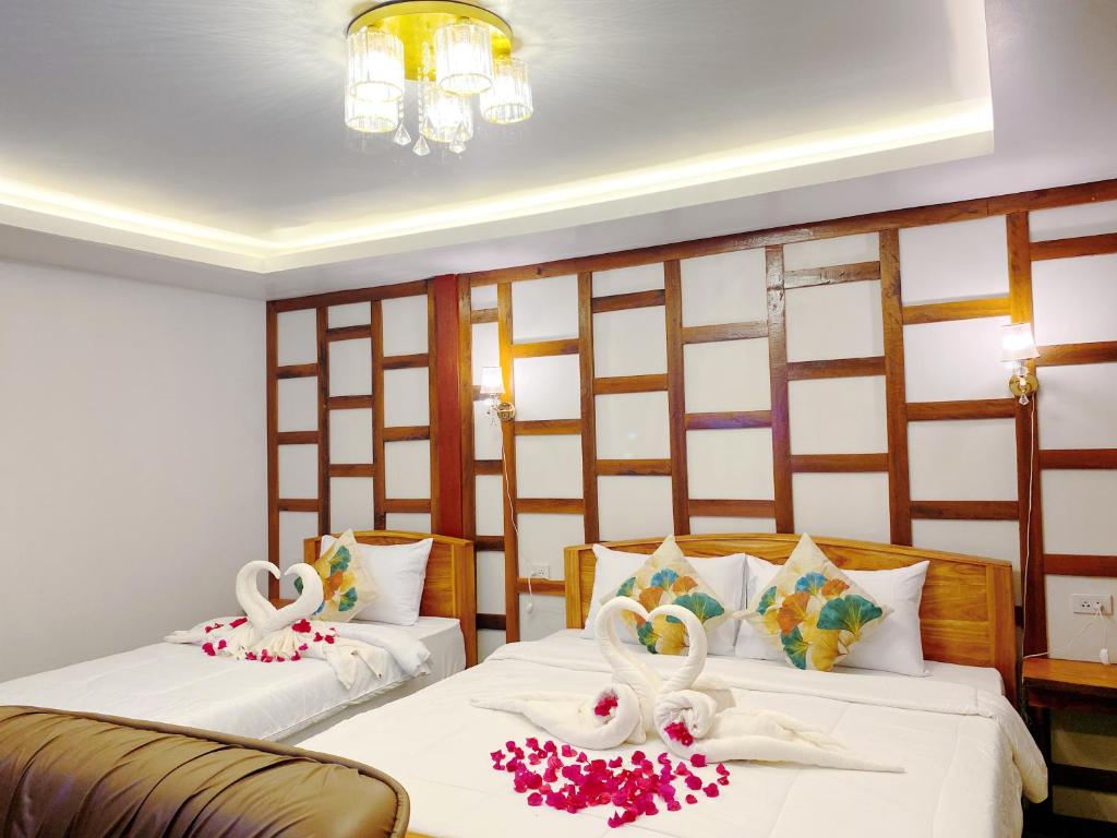 Relaxing House Koh Yao Yai في كو ياو ياي: سريرين في غرفة عليها بجعة