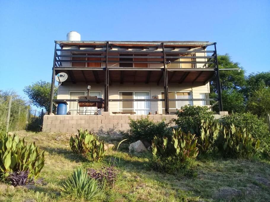 Casa Hebe في فيلا باركيه سيكيمان: منزل على تل والنباتات أمامه