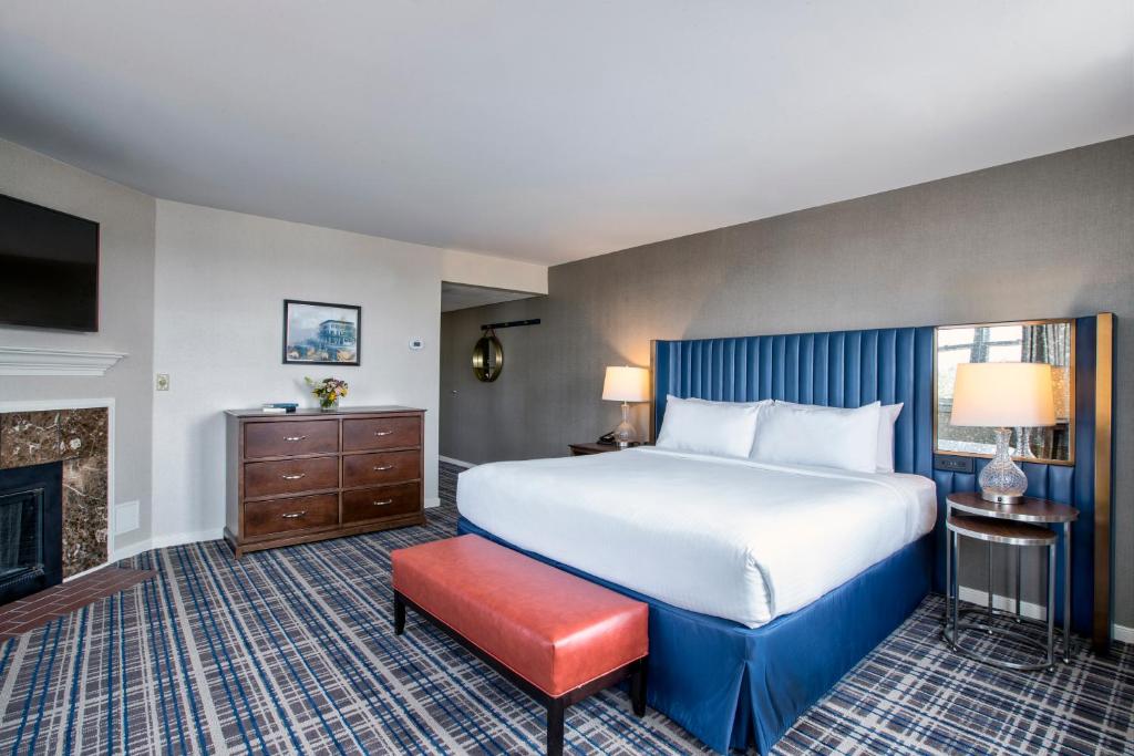 ゲティスバーグにあるGettysburg Hotelの大きなベッドと暖炉が備わるホテルルームです。