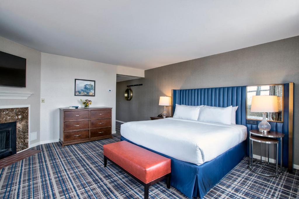 a hotel room with a large bed and a fireplace at Gettysburg Hotel in Gettysburg