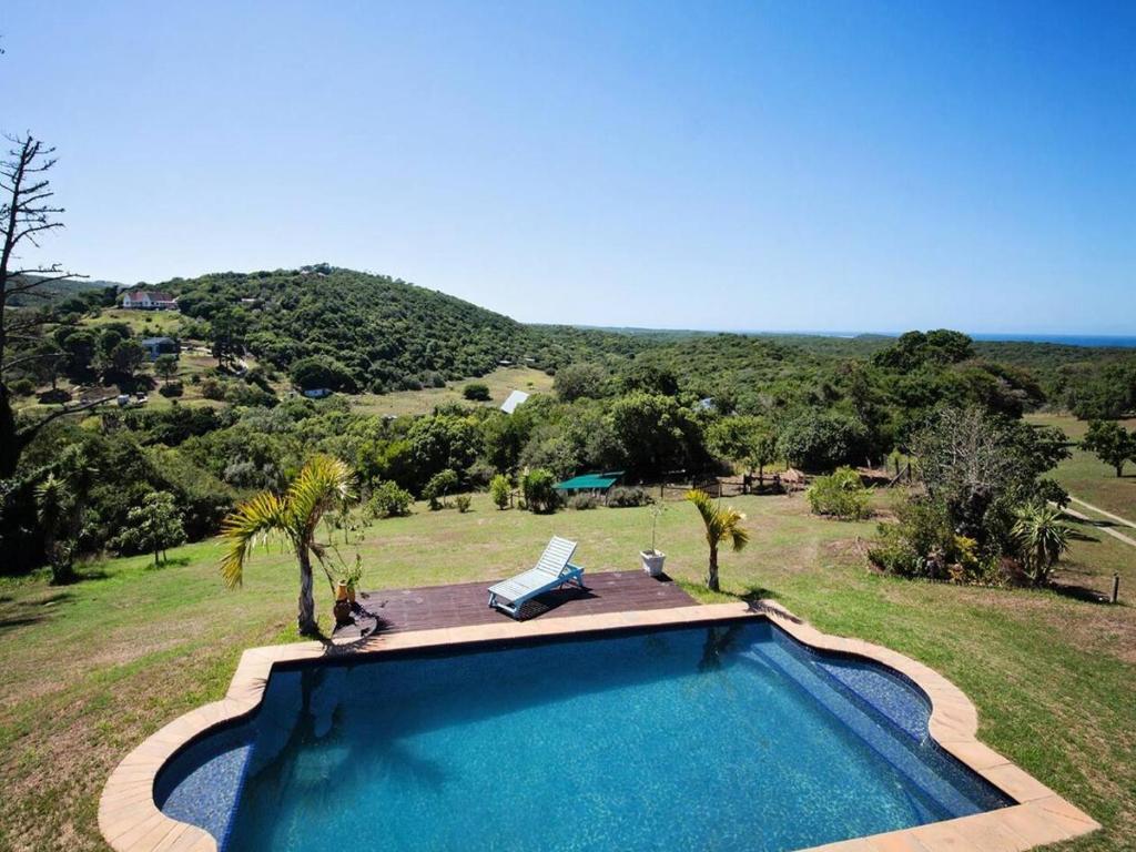 a swimming pool with a view of a field at Chelsea Manor in Kini Bay