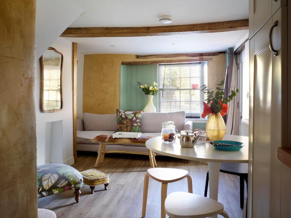 un soggiorno con tavolo e divano di The Coach House - Market Deeping a Market Deeping