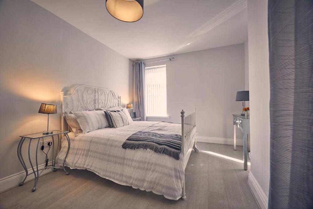 a white bedroom with a bed and a window at Host & Stay - Roselyn By The Sea in Newbiggin-by-the-Sea