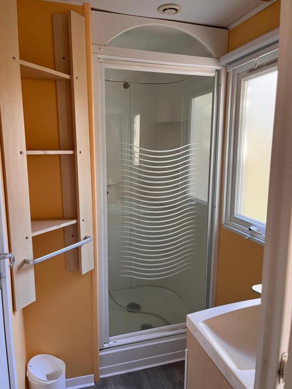 a glass shower in a bathroom with a sink at Camping le Rancho in Argelès-sur-Mer