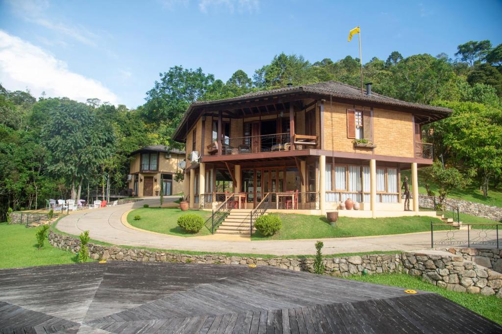 ein Holzhaus mit einem Gehweg drum herum in der Unterkunft Pousada Terra Crua in Visconde De Maua