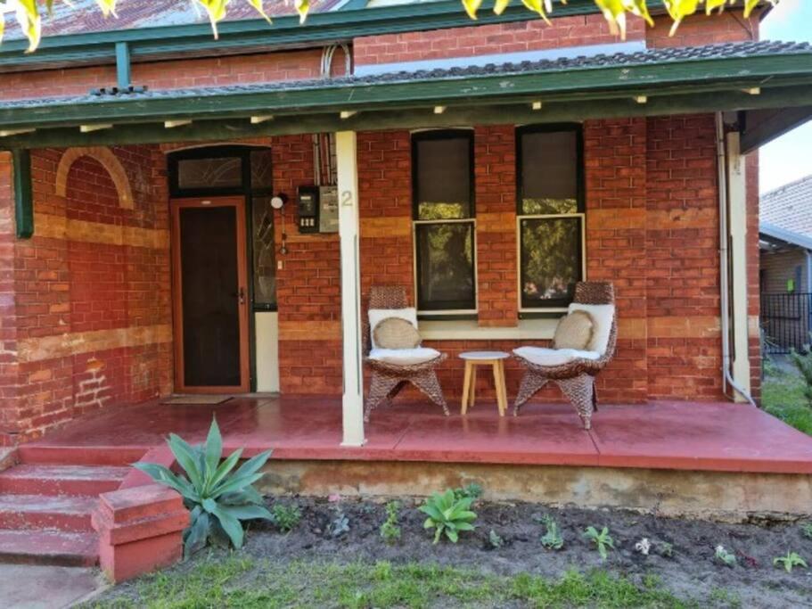 une maison avec 2 chaises et une table sur une terrasse couverte dans l'établissement North Perth Stylish Character Home Close CBD, à Perth