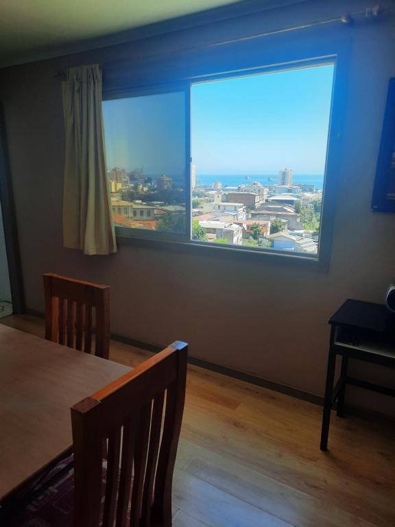 comedor con ventana grande y mesa en loft vista a la bahía en Valparaíso