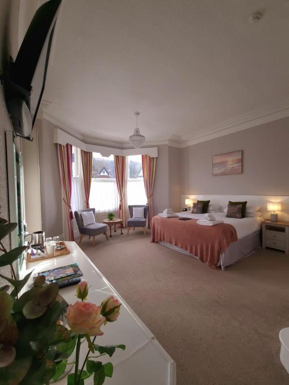 スカーバラにあるThe Cavendishのベッドと花のテーブルが備わるホテルルームです。