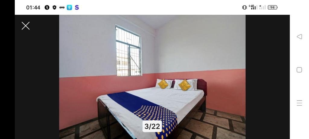 uma pequena cama num quarto com uma parede vermelha e branca em Hotel Harsh Regency em Bhopal