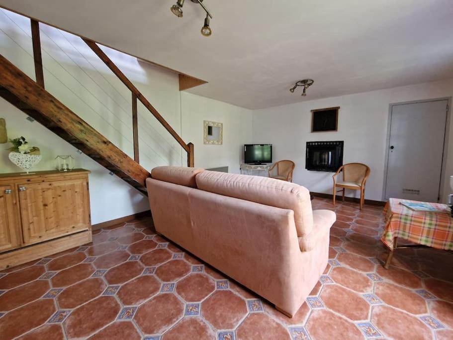 a living room with a couch and a staircase at Gîte de charme - Normandie in Breteuil-sur-Iton