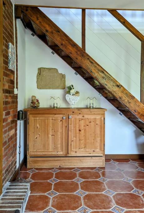 a attic room with a wooden cabinet and a brick wall at Gîte de charme - Normandie in Breteuil-sur-Iton