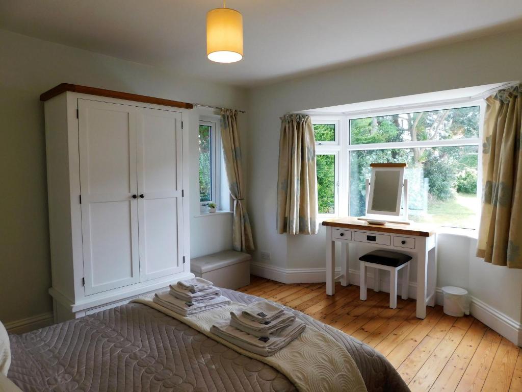 a bedroom with a bed and a desk and a window at The Sidings in Sheringham