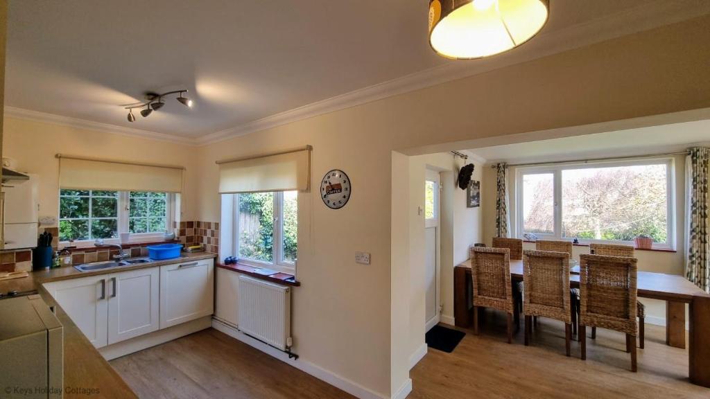 a kitchen and dining room with a table and chairs at Walma in West Runton