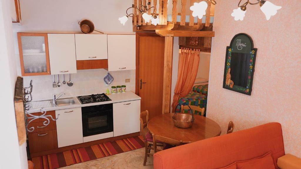 a kitchen with a table and a stove top oven at Accogliente Appartamento Foppolo in Foppolo