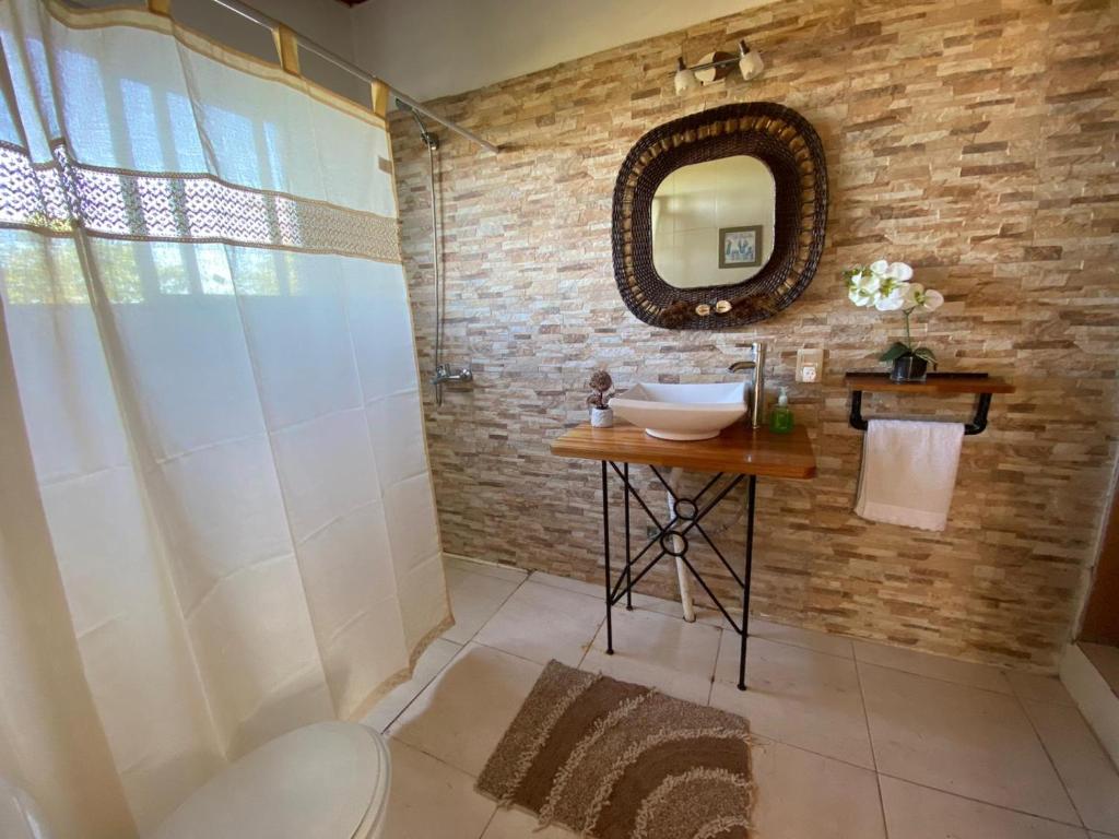 y baño con lavabo y espejo. en Posada Mahatma en Tacuarembó