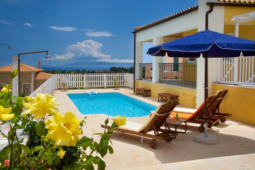 um pátio com uma piscina e um guarda-sol em Villa Karavisianikos Faros em Karavádhos