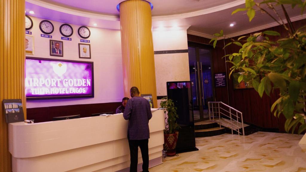 un hombre jugando un videojuego en un vestíbulo en Airport GoldenTulip Hotel en Lagos
