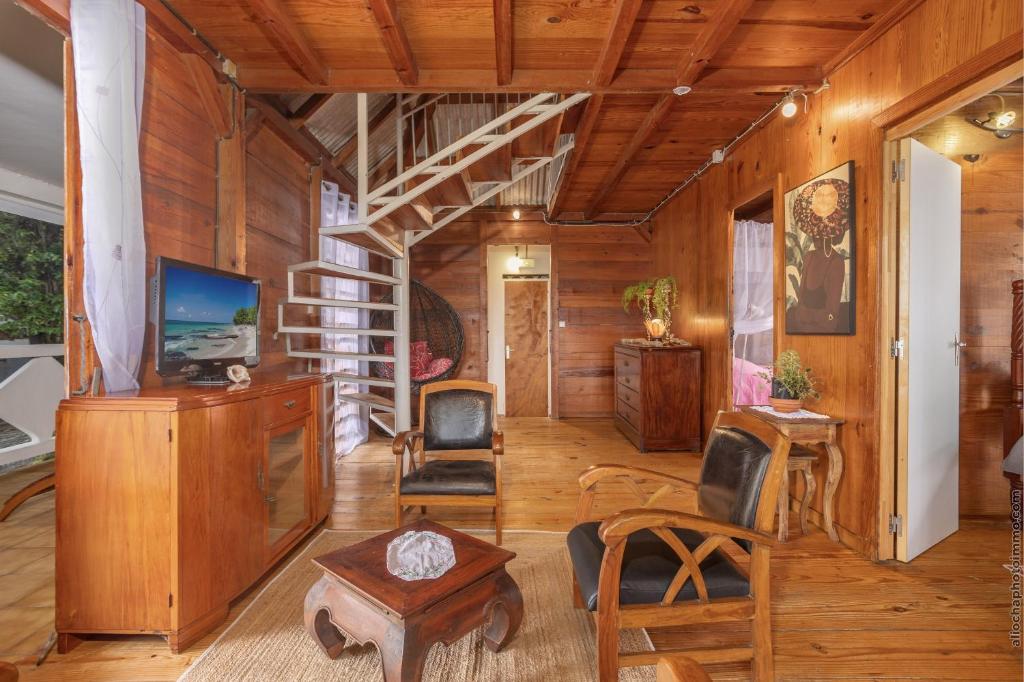 a living room with wooden walls and a spiral staircase at écrin de Monpierre in Brion
