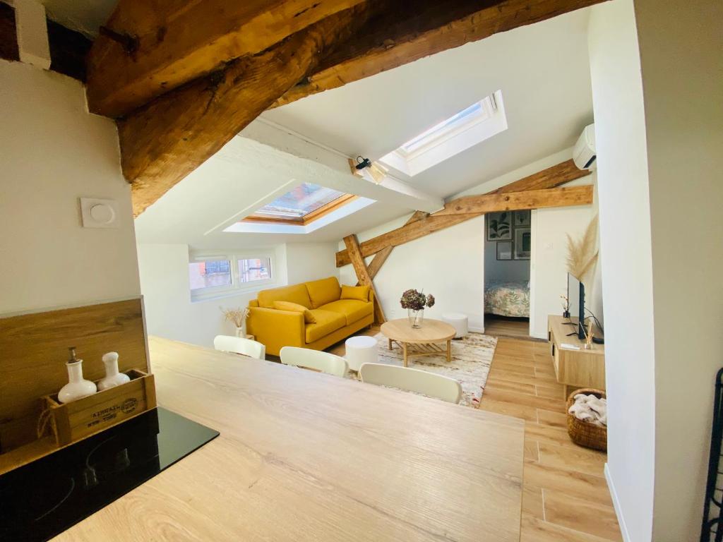 un salon avec un canapé jaune et une table dans l'établissement L'Hortensia Saint Aubin, à Toulouse