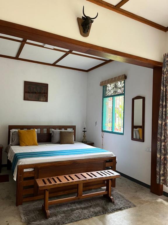 1 dormitorio con cama y banco. en Lobo's Villa en Kurunegala