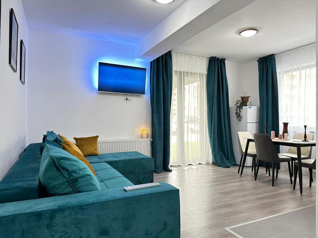 a living room with a blue couch and a table at Luxury Apartments near Coresi Mall by GLAM in Braşov