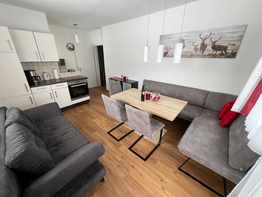 sala de estar con sofá y mesa con sillas en Haus Alpina Ski In & Ski Out, en Schladming