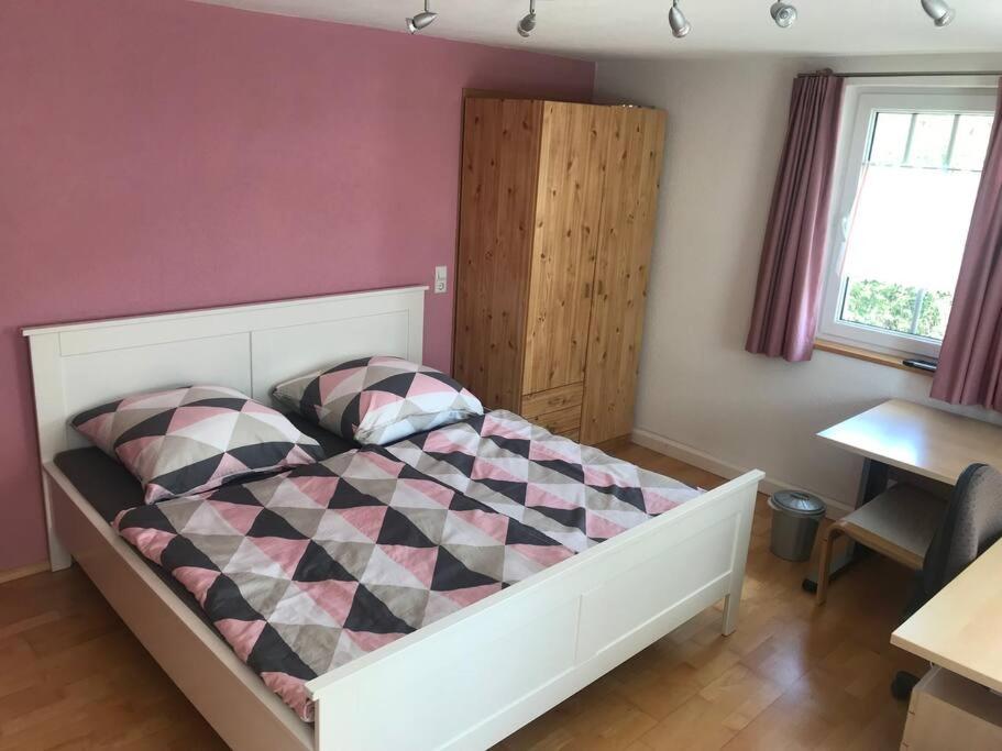 Schlafzimmer mit einem Bett mit einer Schachtel in der Unterkunft Ferienzimmer Oelhaf Zimmer in Rosé Self Check-In mit Key-Tresore in Wilhelmsdorf