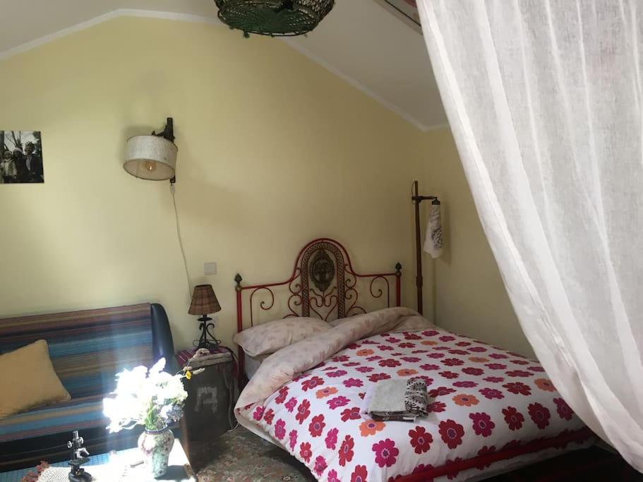 een slaapkamer met een bed met een rood en wit dekbed bij A Barraquinha 30 steps from sea in Apúlia
