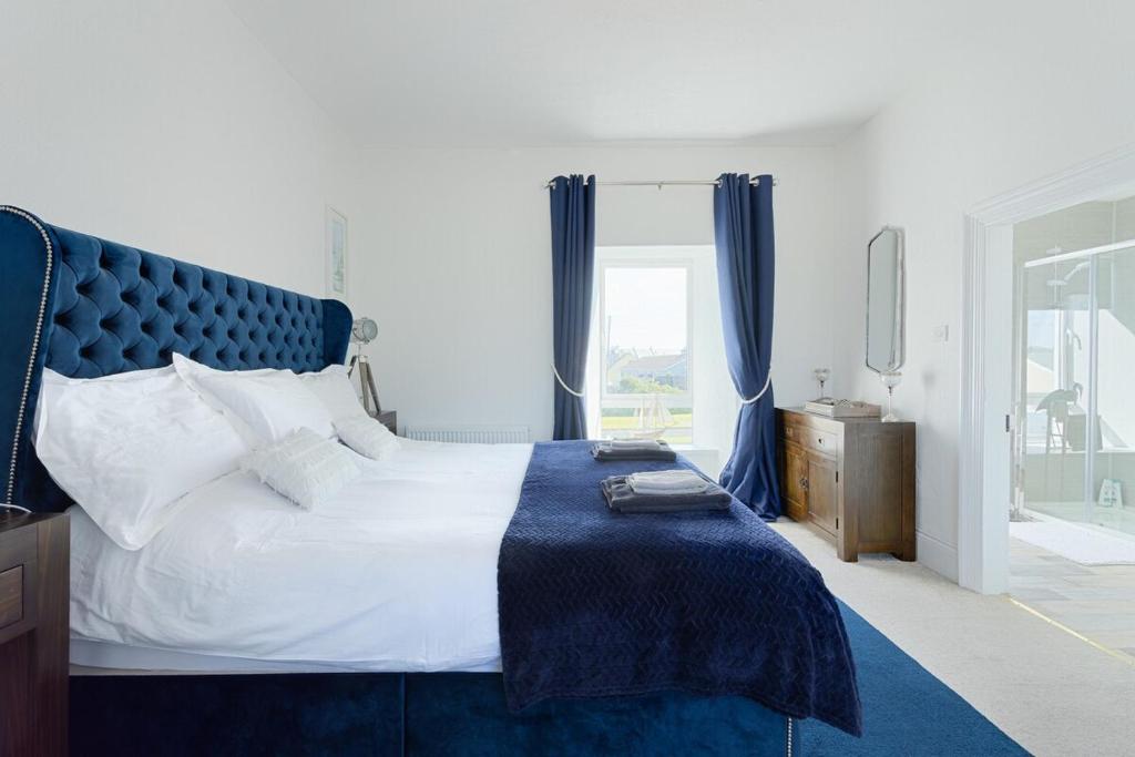 リスカナーにあるHolland House No1のベッドルーム1室(大型ベッド1台、青いヘッドボード付)