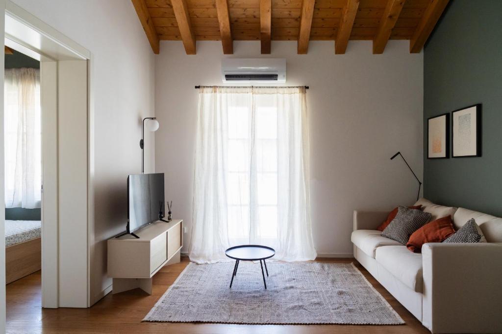 a living room with a couch and a tv at Private Parking, Two Bedrooms & Two Bathrooms - Elegant Apartment in Old Town in Udine