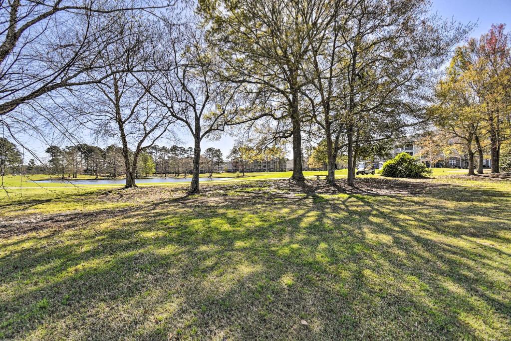 a park with trees in the middle of a field at Crow Creek Golf Club Condo with Community Perks! in Calabash