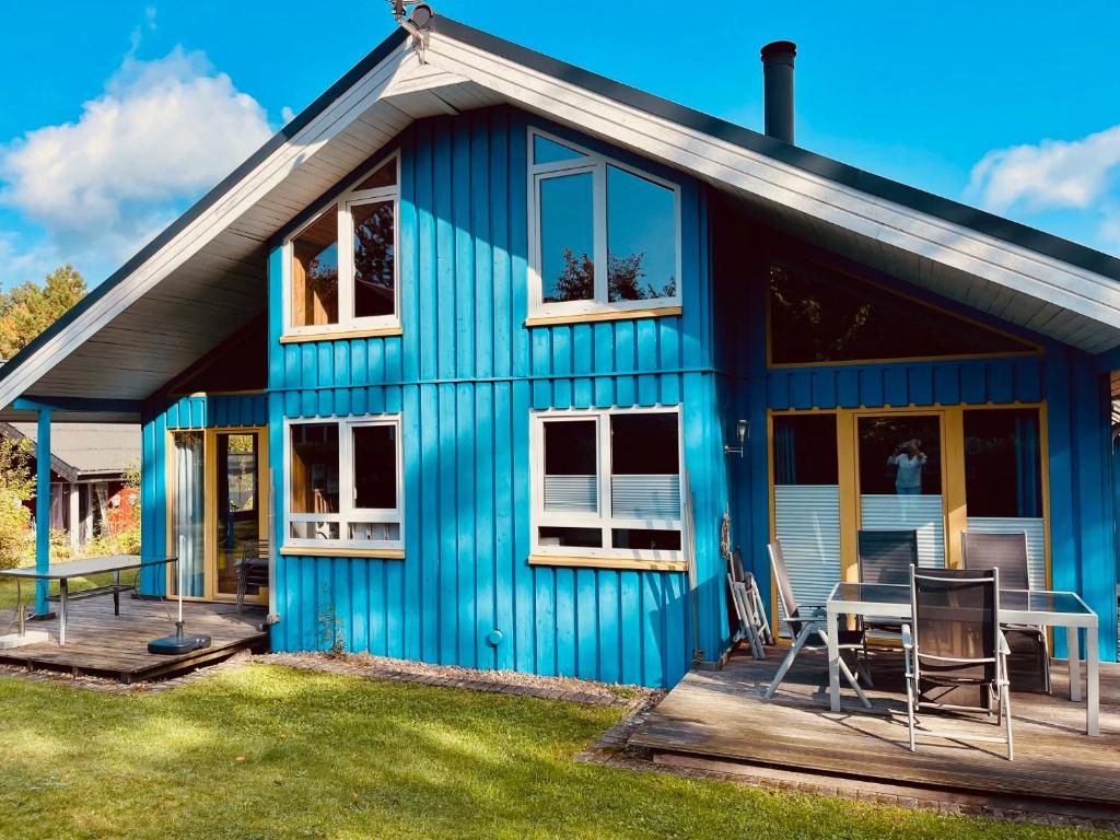 a blue house with a table on a deck at Extertal-Ferienpark - Premium Ferienhaus Sauna Wandern #56a in Extertal