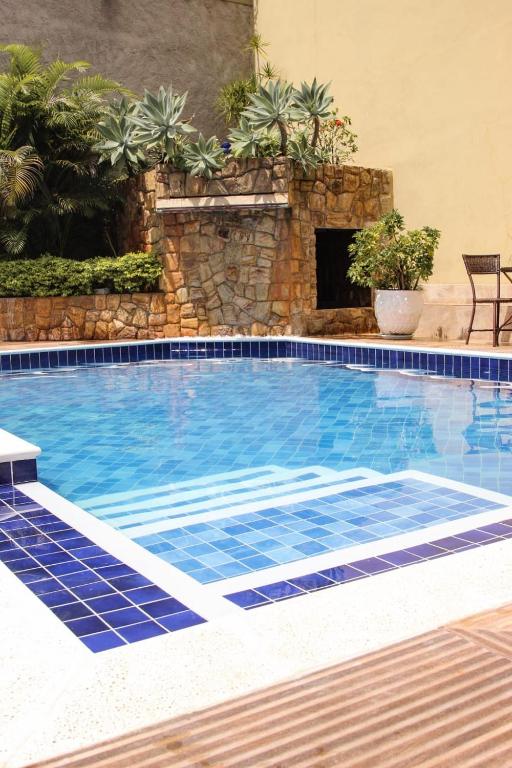 a swimming pool with blue tiles in a resort at Pousada Cambucá de Cabo Frio in Cabo Frio